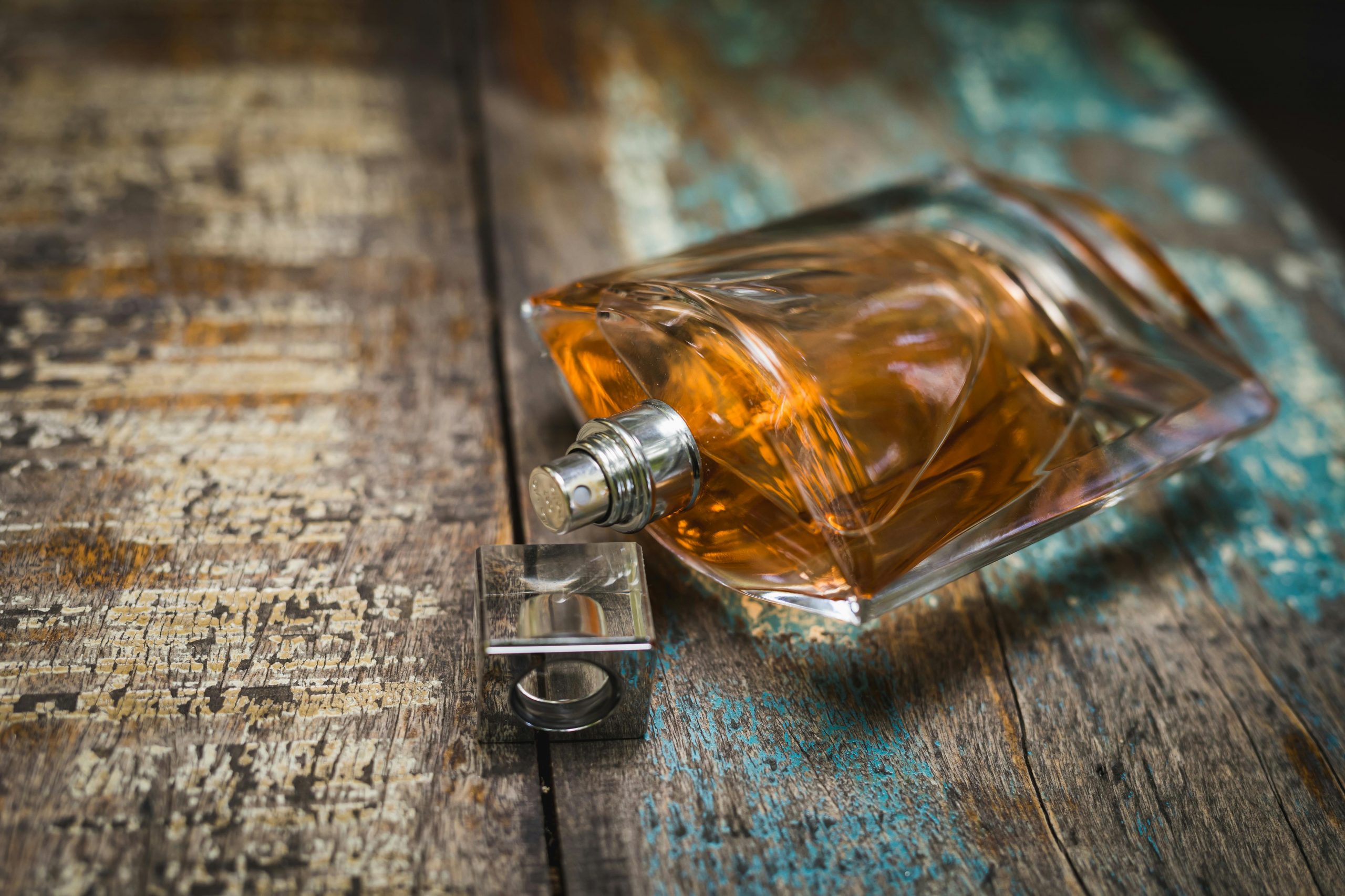 Artistic perfume bottle on rustic wooden surface, perfect for fragrance ads.