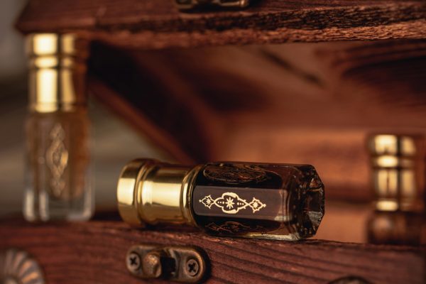 pexels photo 8796359 8796359 Close-up of vintage perfume bottles displaying intricate golden designs, set on a wooden surface.